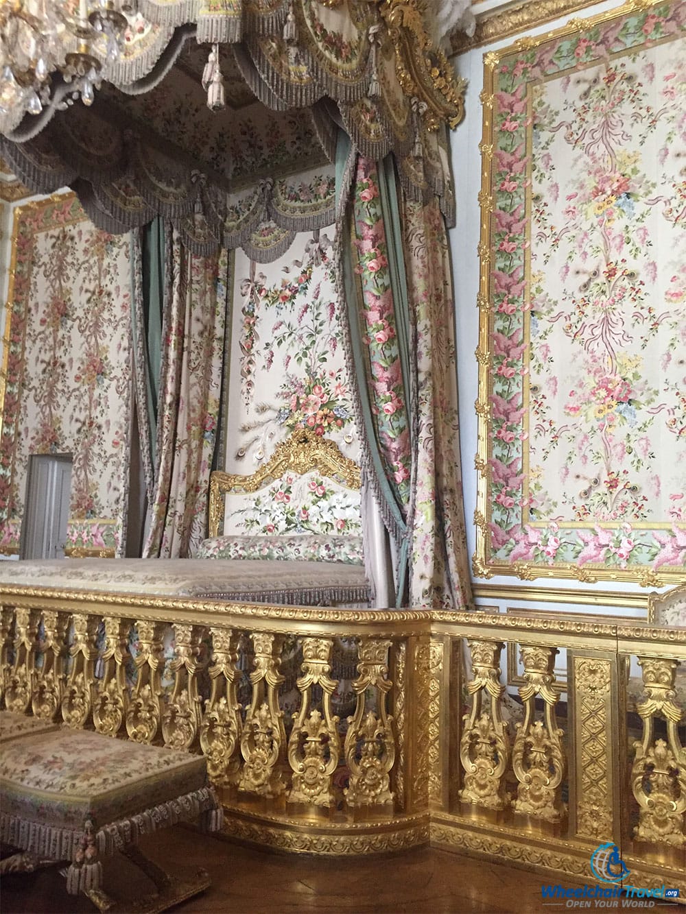 PHOTO DESCRIPTION: Bed with floral drapes extending from the ceiling.