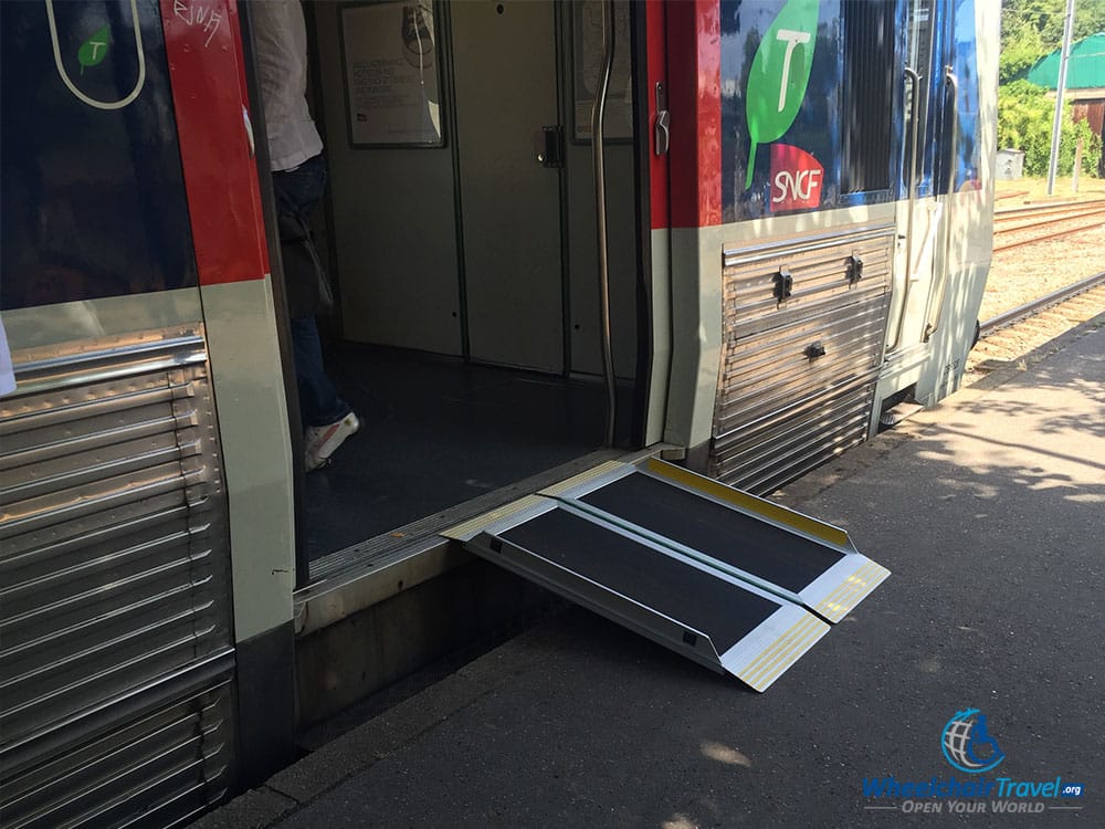 PHOTO DESCRIPTION: RER train at Versailles-Rive Droite Station with a wheelchair accessible ramp laid out.