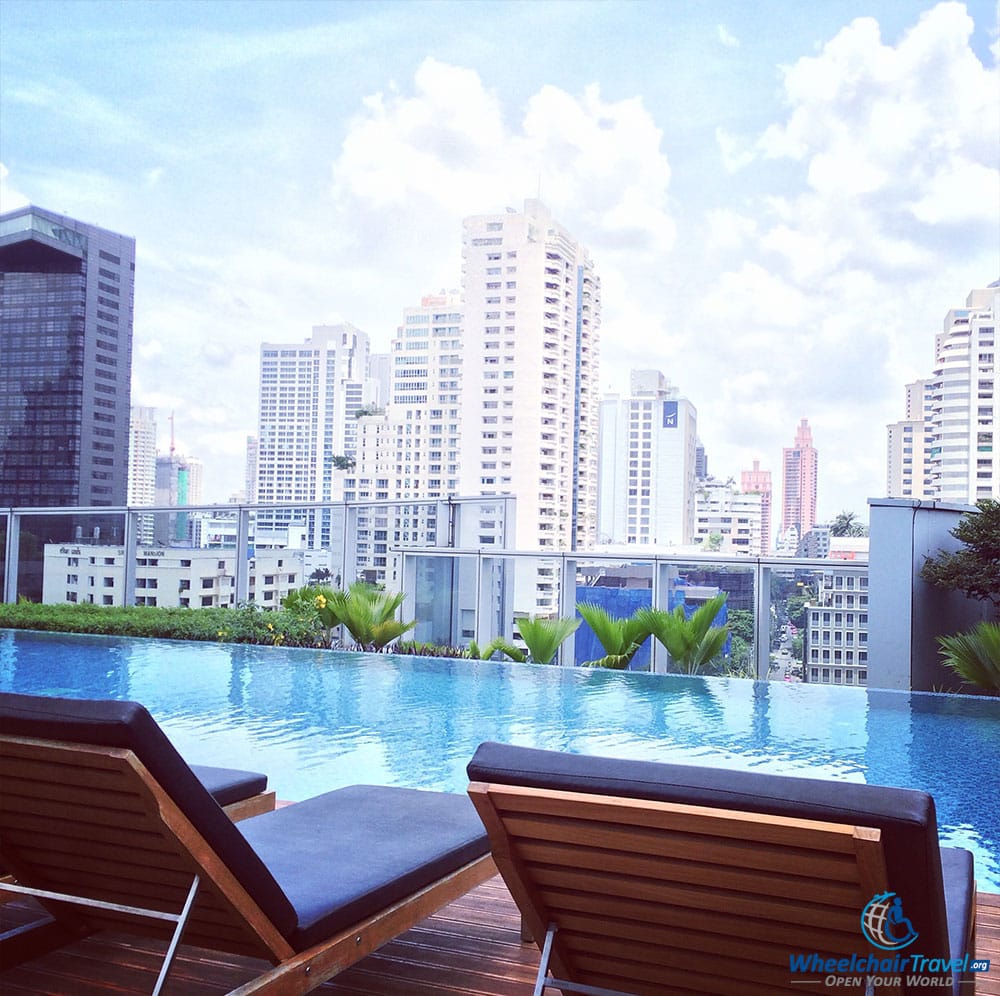 PHOTO DESCRIPTION: Lounge chairs next to a rooftop pool in Bangkok, Thailand.