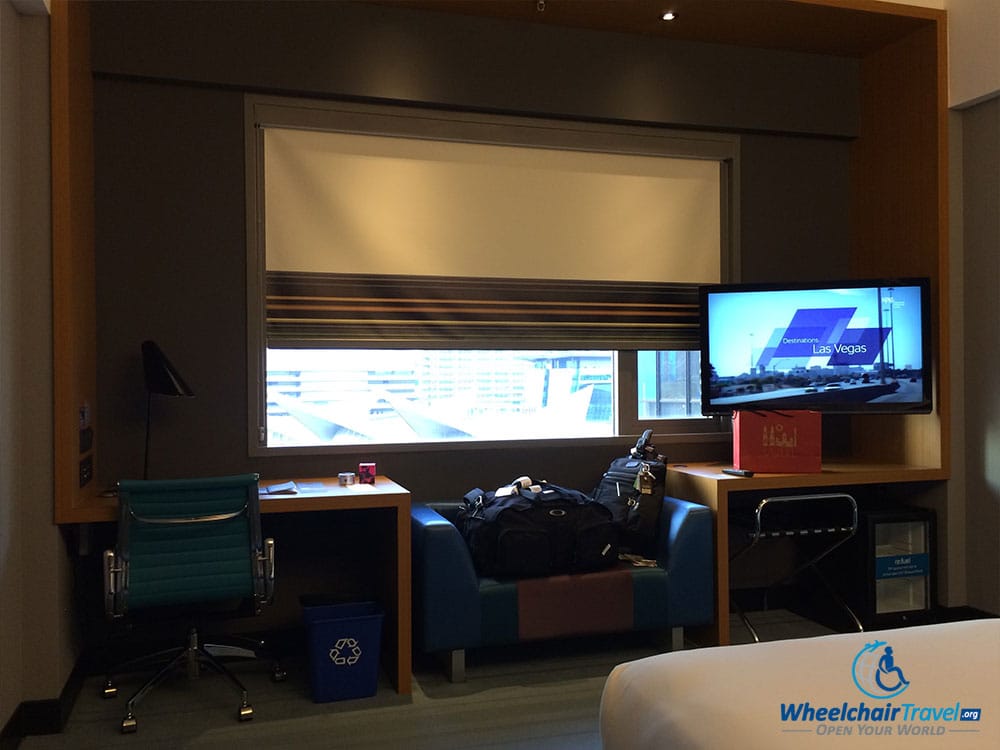 PHOTO DESCRIPTION: Desk, TV and Sofa on the wall opposite the bed at the Aloft Kuala Lumpur Sentral Hotel.