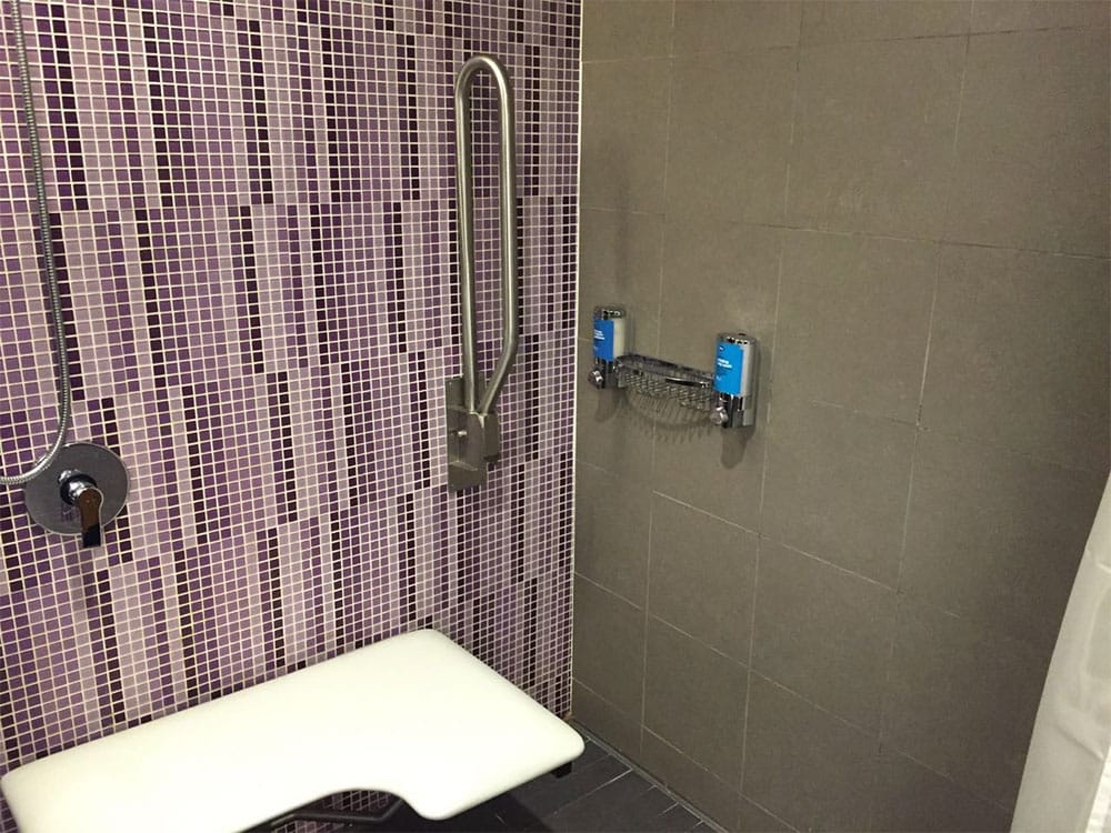 PHOTO DESCRIPTION: Shampoo and soap dispensers in roll-in shower at Aloft Kuala Lumpur Sentral Hotel.