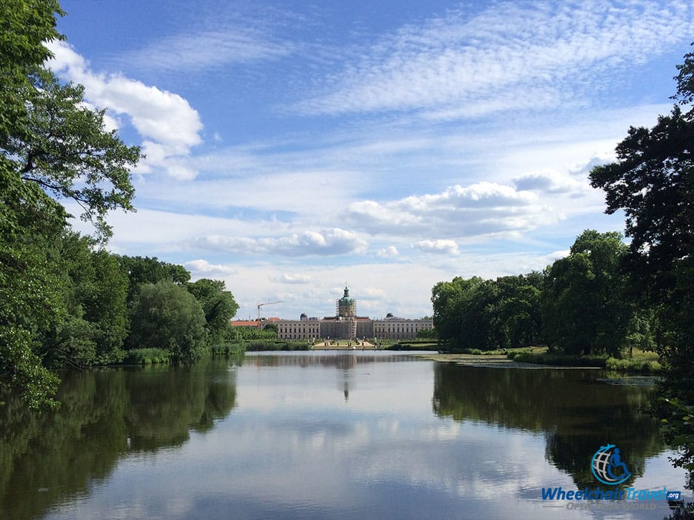 PHOTO DESCRIPTION: The Charlottenburg Palace building, as seen from far across the lake and set against a beautiful blue and white clouded sky.