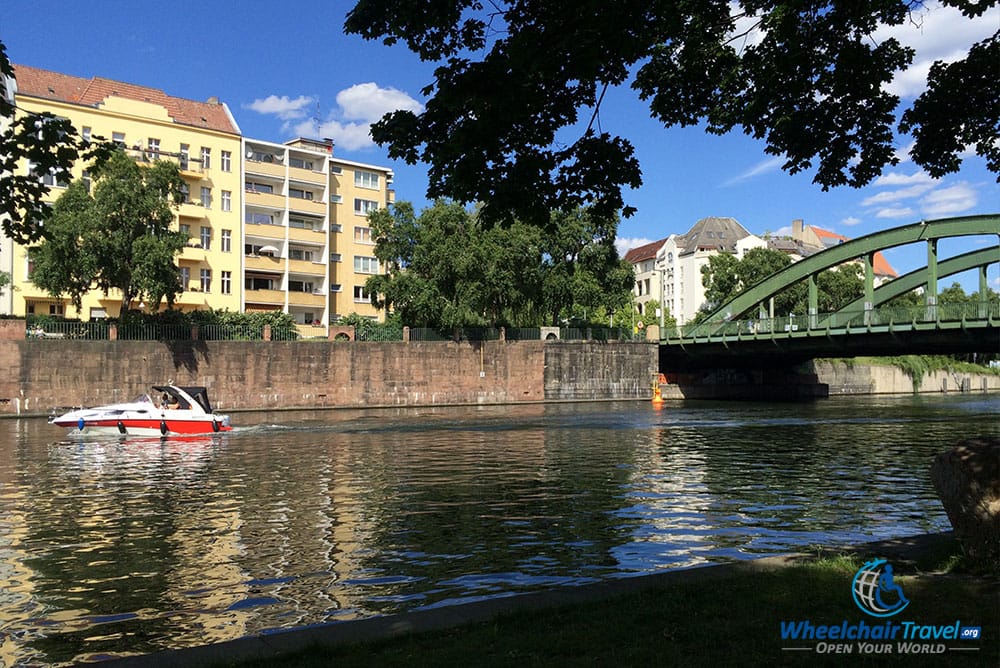 PHOTO DESCRIPTION: Boat passing under bridge that crosses a river adjacent to the palace park.