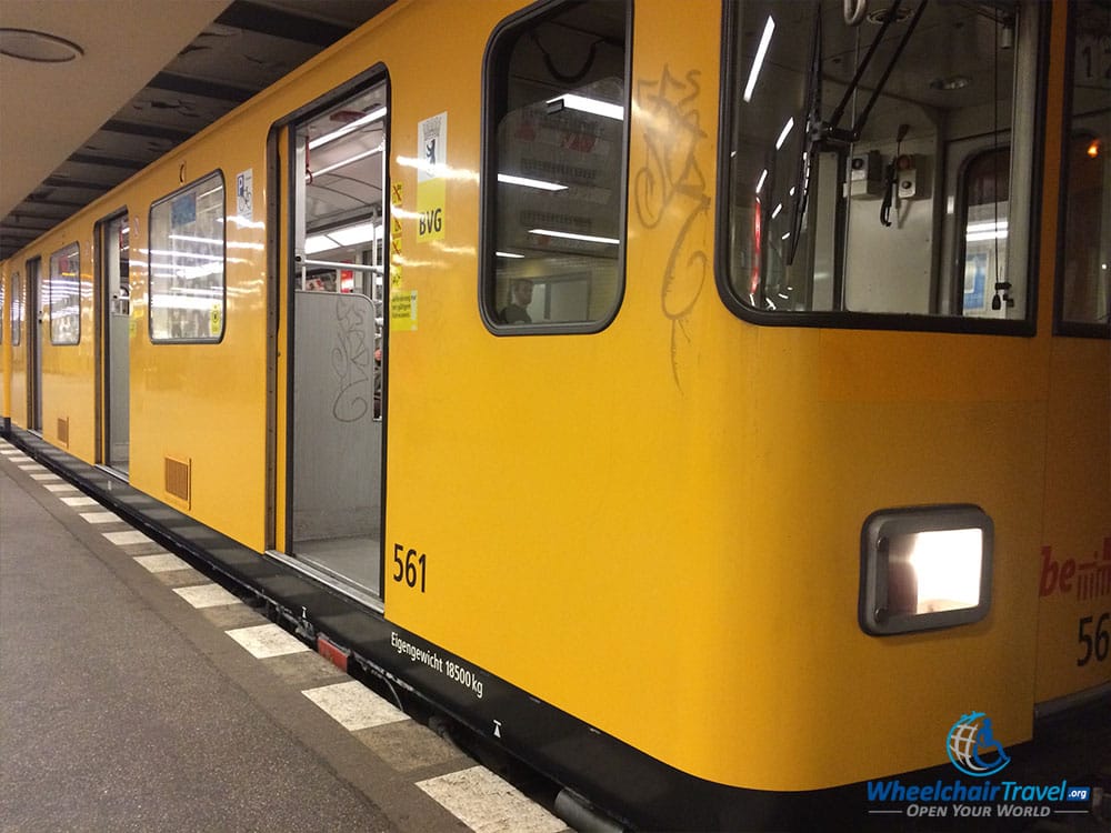 PHOTO DESCRIPTION: A yellow train on the Berlin U-Bahn system with a door entryway sitting 5-6 inches above the platform.