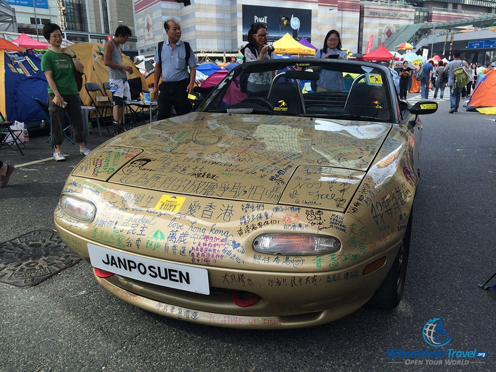 PHOTO DESCRIPTION: Convertible car covered with graffiti messages.