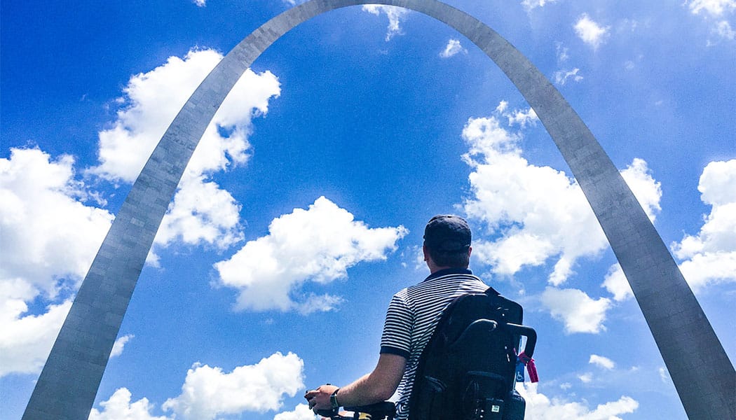 PHOTO: Wheelchair user John Morris in front of the St. Louis Arch.