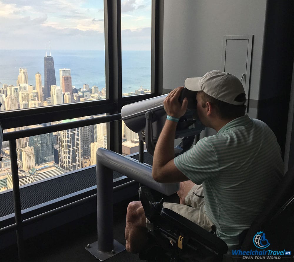 PHOTO: John looking through a wheelchair accessible telescope at Skydeck Chicago Willis Tower.