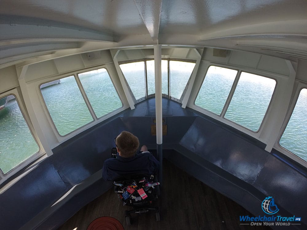 PHOTO: Wheelchair user John looking through the windows at the bow of the Vista King boat in Milwaukee.