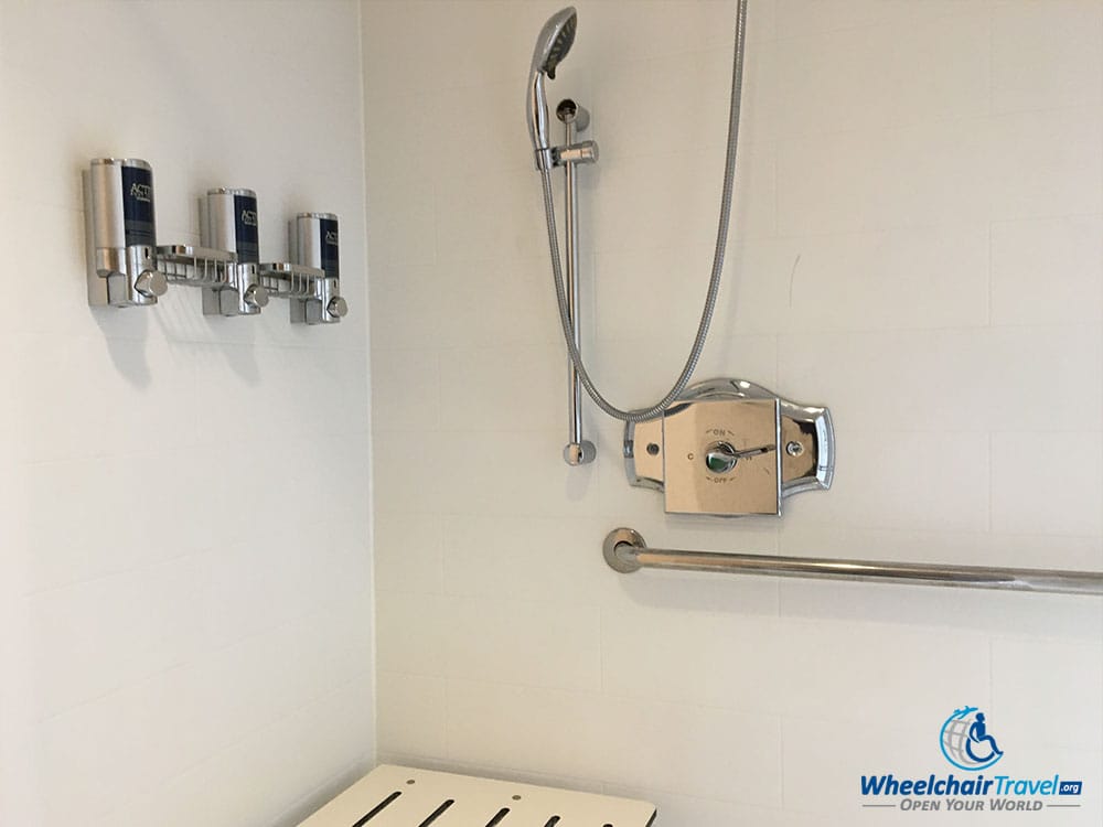 Soap dispensers attached to the wall behind the shower seat