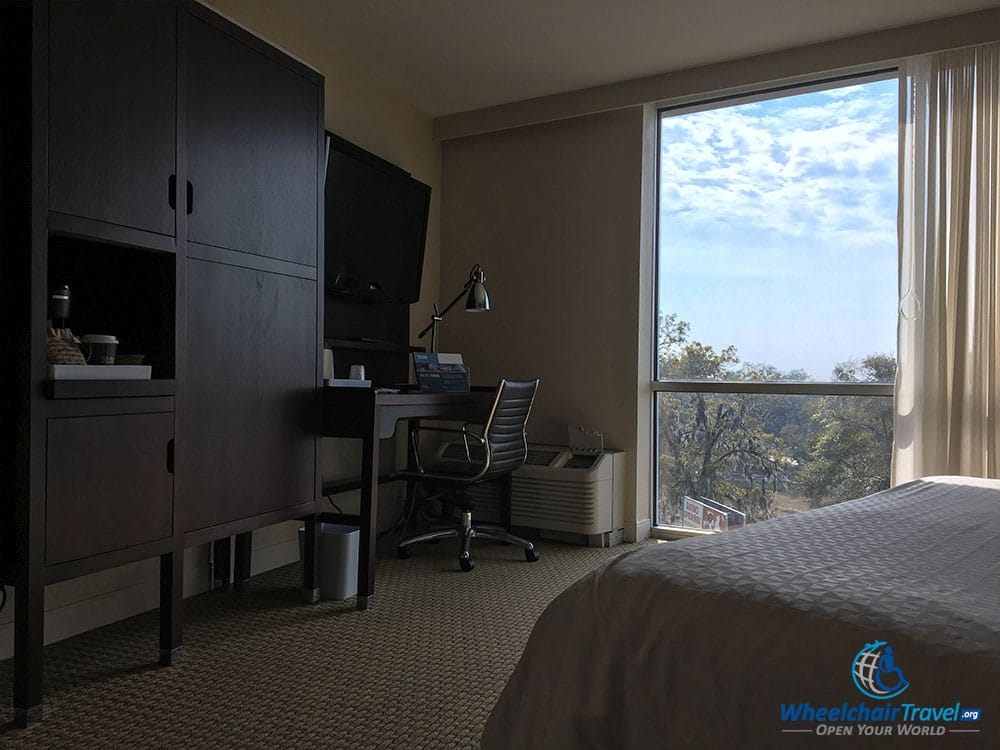 View of the bedroom's TV, desk and armoire.