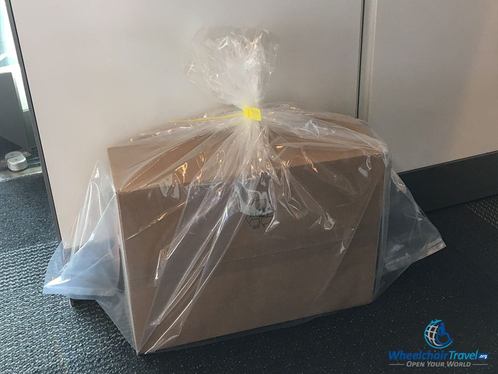 Laptop packed inside of a cardboard box, wrapped in a plastic bag