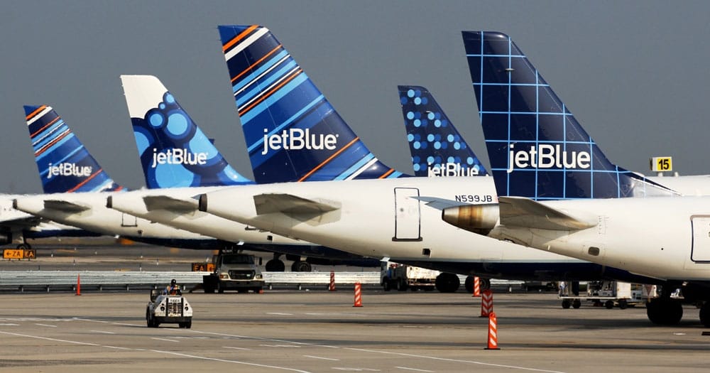 JetBlue aircraft parked at airport gates, each with a different tail design.