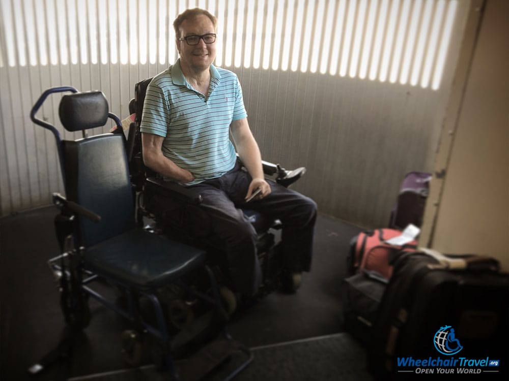 Wheelchair user boards airplane with aisle chair