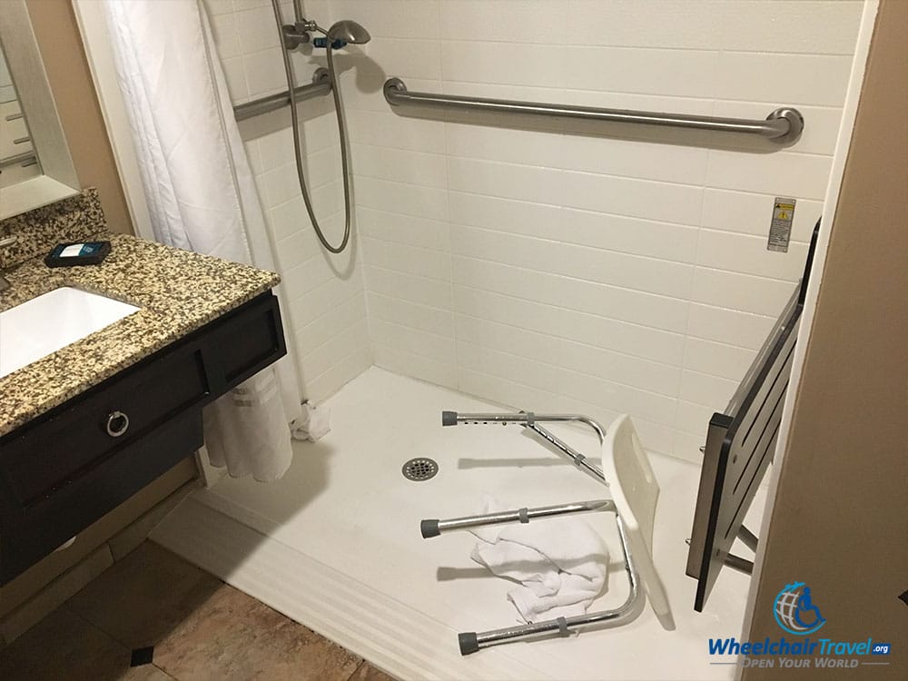 Broken portable shower seat in a roll-in shower at Delta Hotels Orlando Lake Buena Vista.