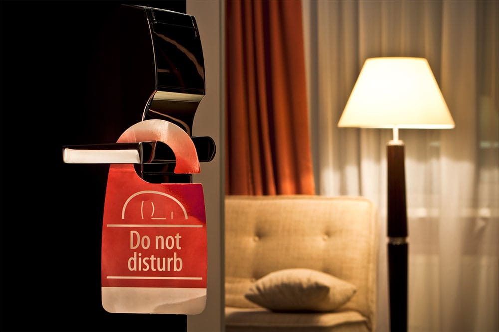 'Do Not Disturb' sign hanging from a hotel room door.