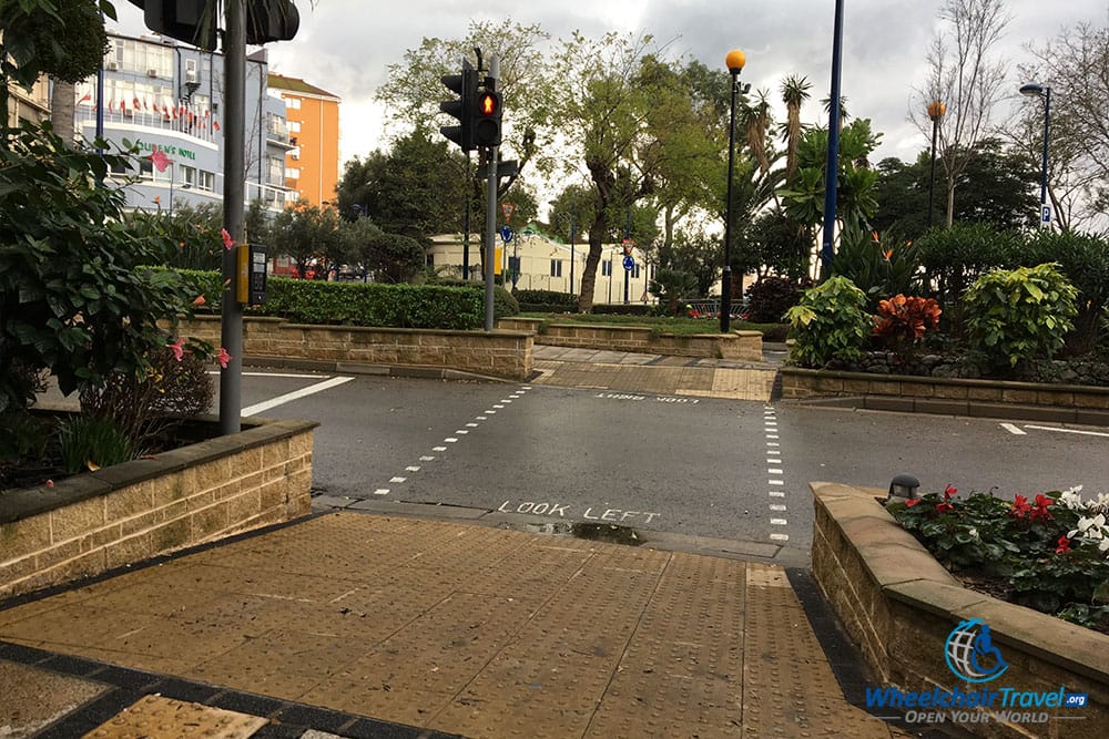 Gibraltar street crossing with curb ramp  and traffic signals.