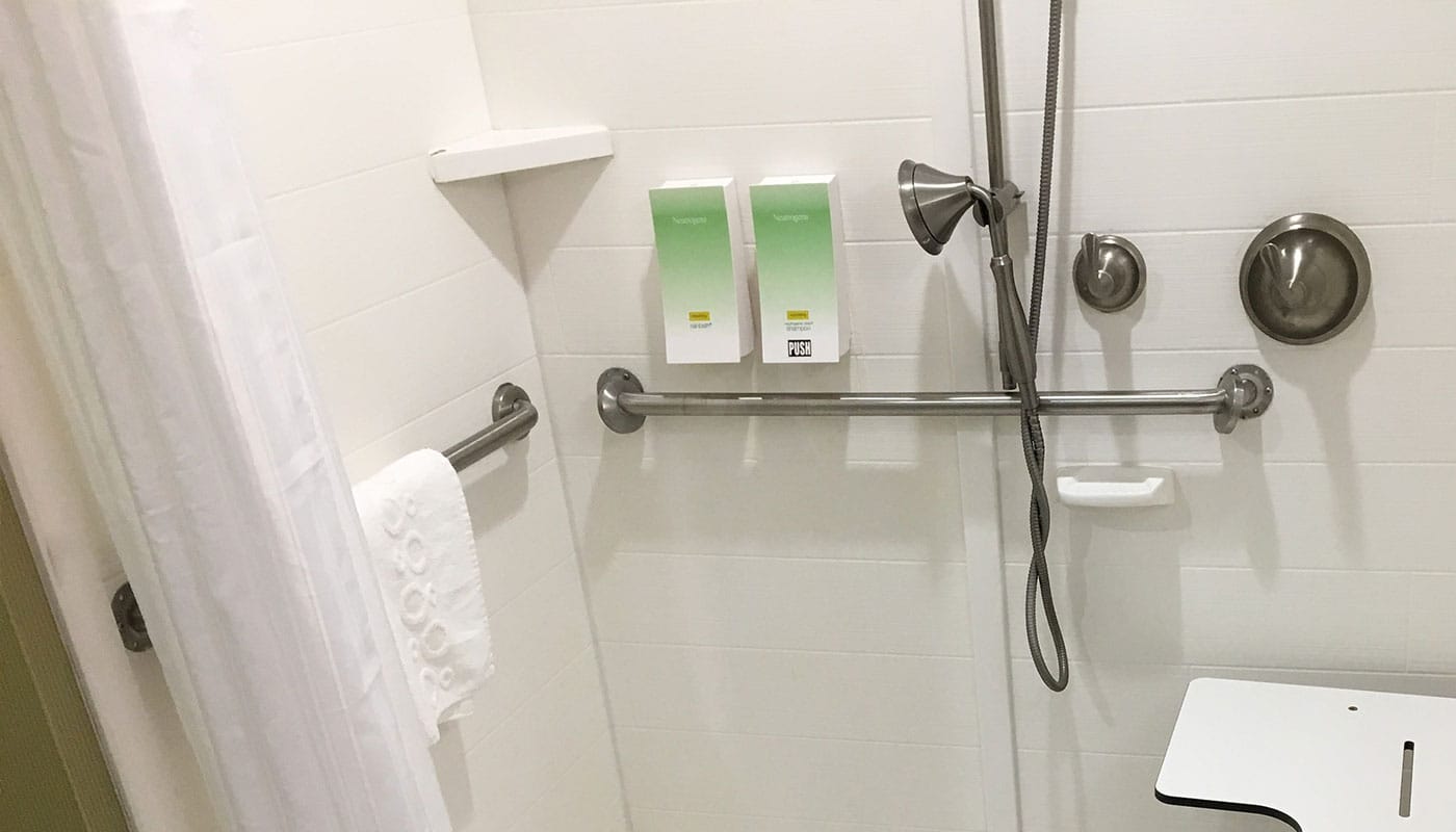 Wall-mounted soap dispensers in hotel bathrooms.