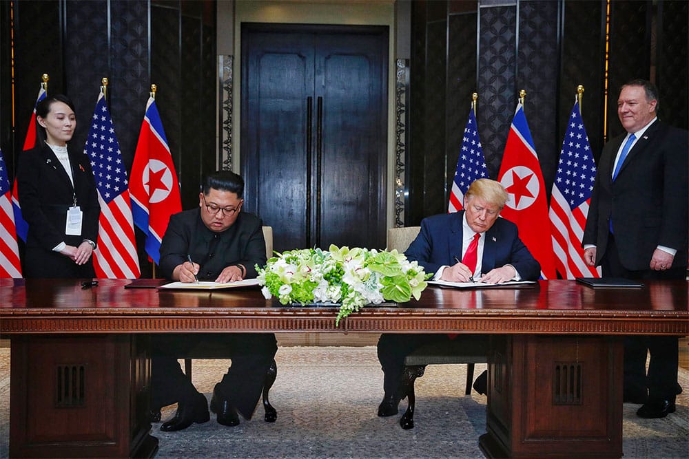 President Donald Trump and Chairman Kim Jong-un sign a bilateral agreement in Singapore. | Photo courtesy NBC News.