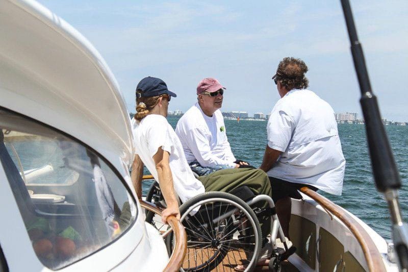 Two wheelchair users on the deck of the Impossible Dream.