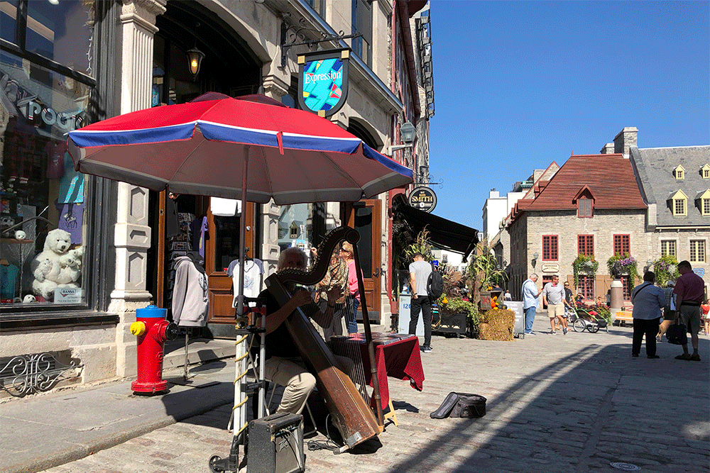 Street performer playing a harp in Old Quebec.