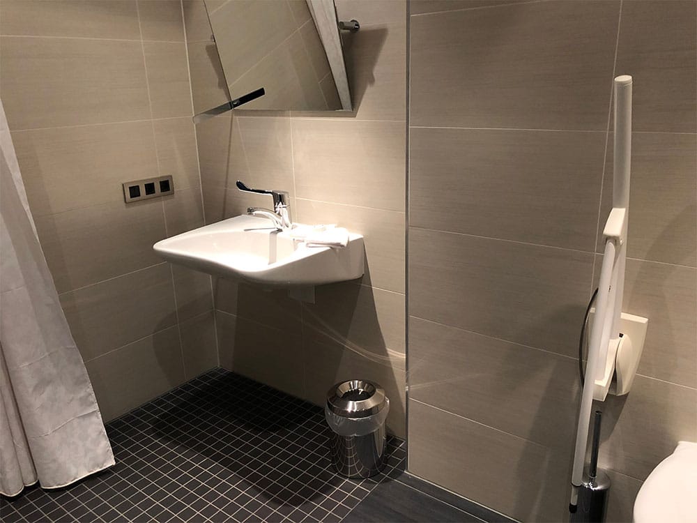 Bathroom sink with angled mirror.