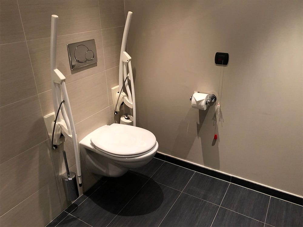 Accessible toilet with folding grab bars.