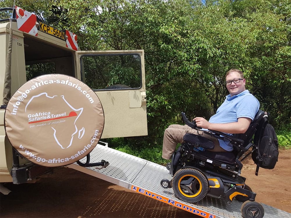 Wheelchair ascending ramp into Land Cruiser on safari.