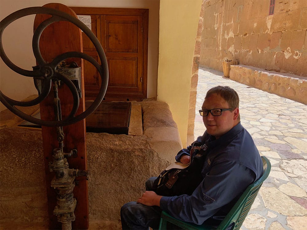 Sittig in a plastic chair in front of Moses' Well.