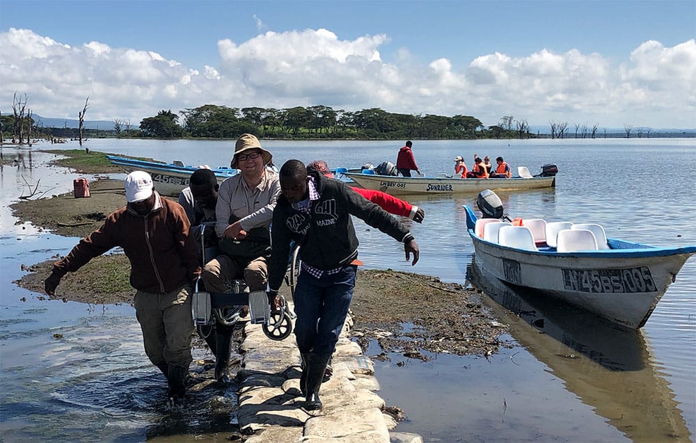 Four men helping to carry me in my wheelchair.