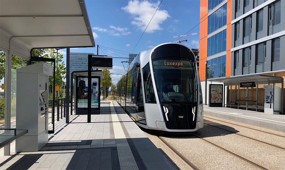 Luxembourg tram arriving at open-air station stop.