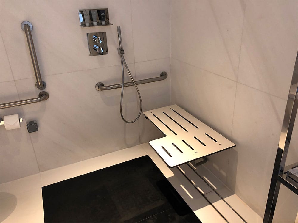 Roll-in shower with wall-mounted seat.