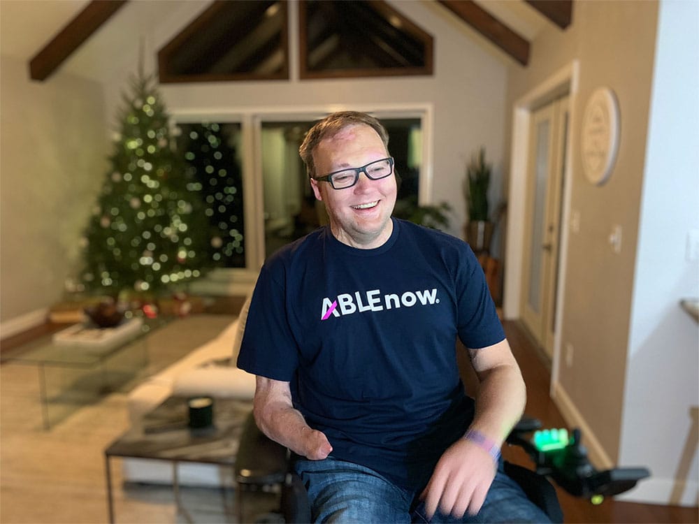 John pictured at home wearing an ABLEnow t-shirt.