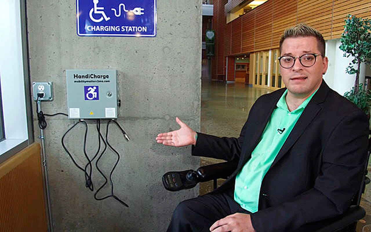 Blayne Amson, the ADA/Title VI Administrator for Bellevue, showcases one of the city's wheelchair charging stations.