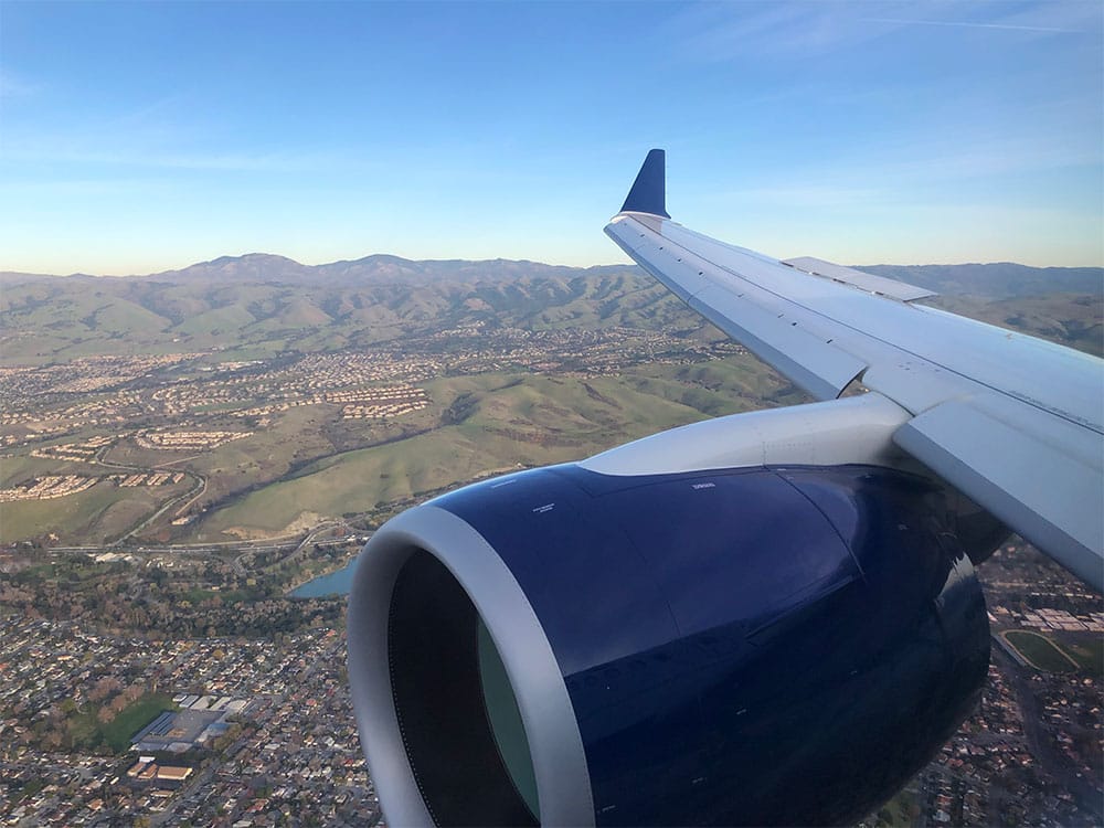 View of aircraft engine and wing through window.