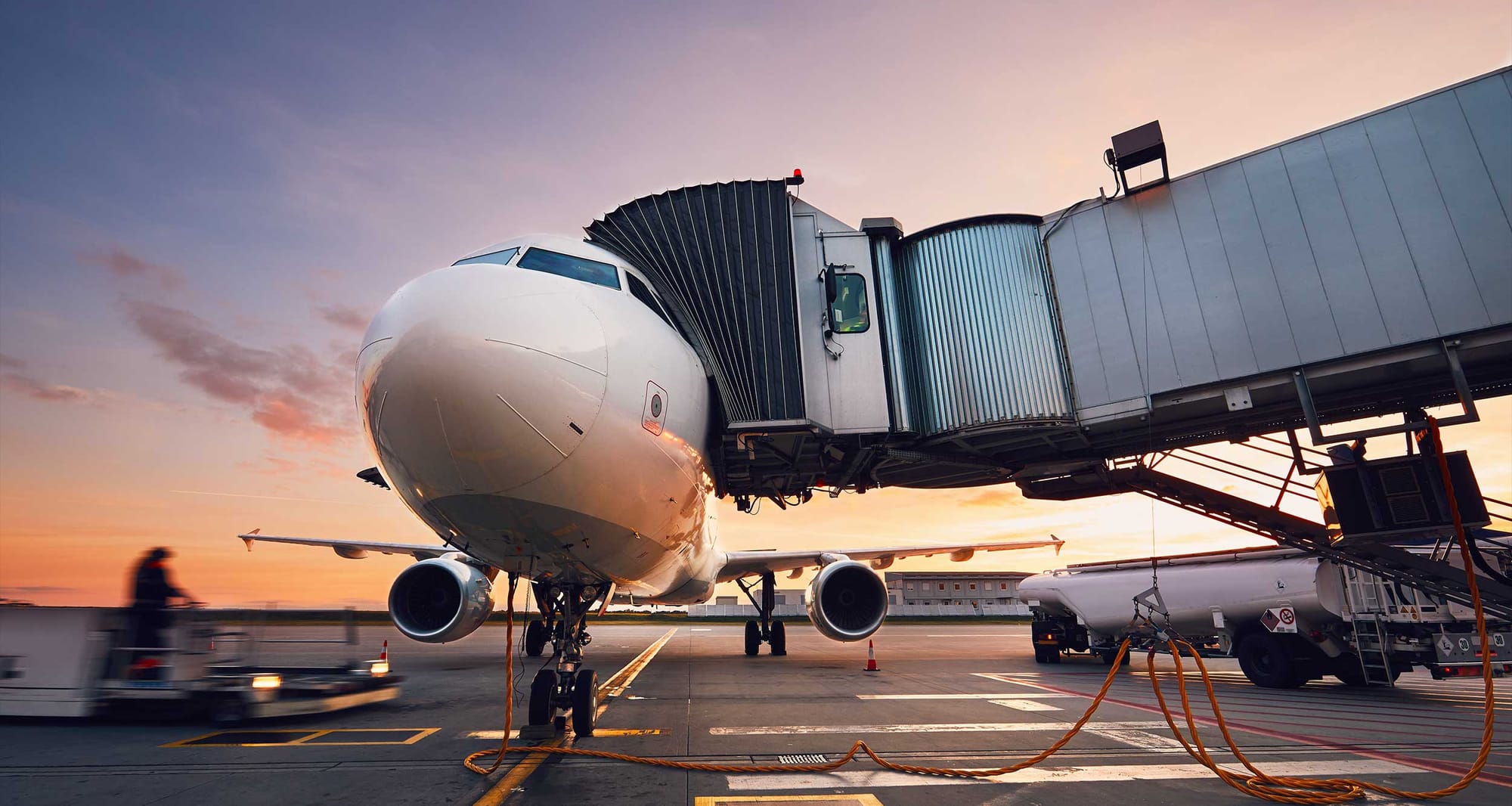 Airplane parked at airport boarding gate jet bridge.