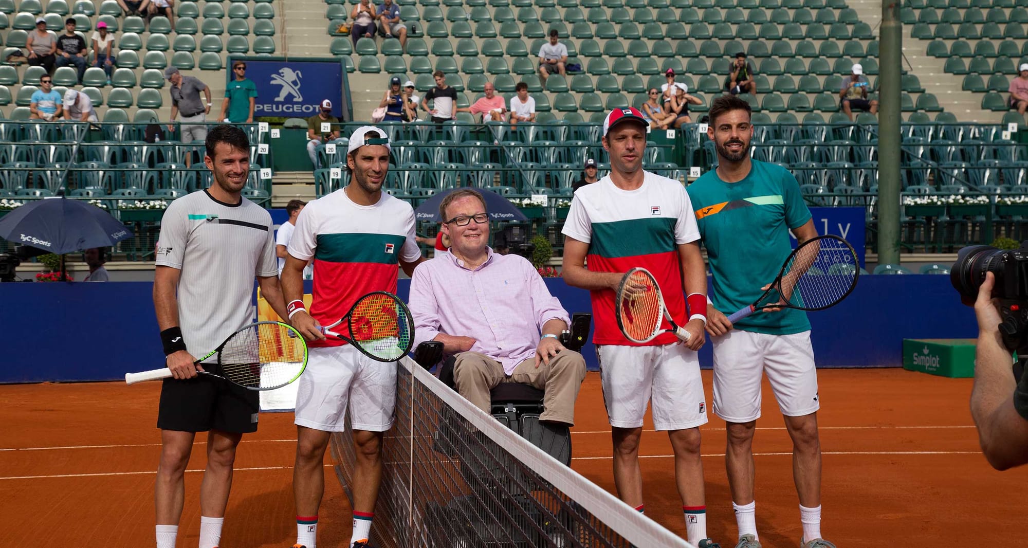 Wheelchair user at the net with 2020 Argentina Open Doubles finalists.