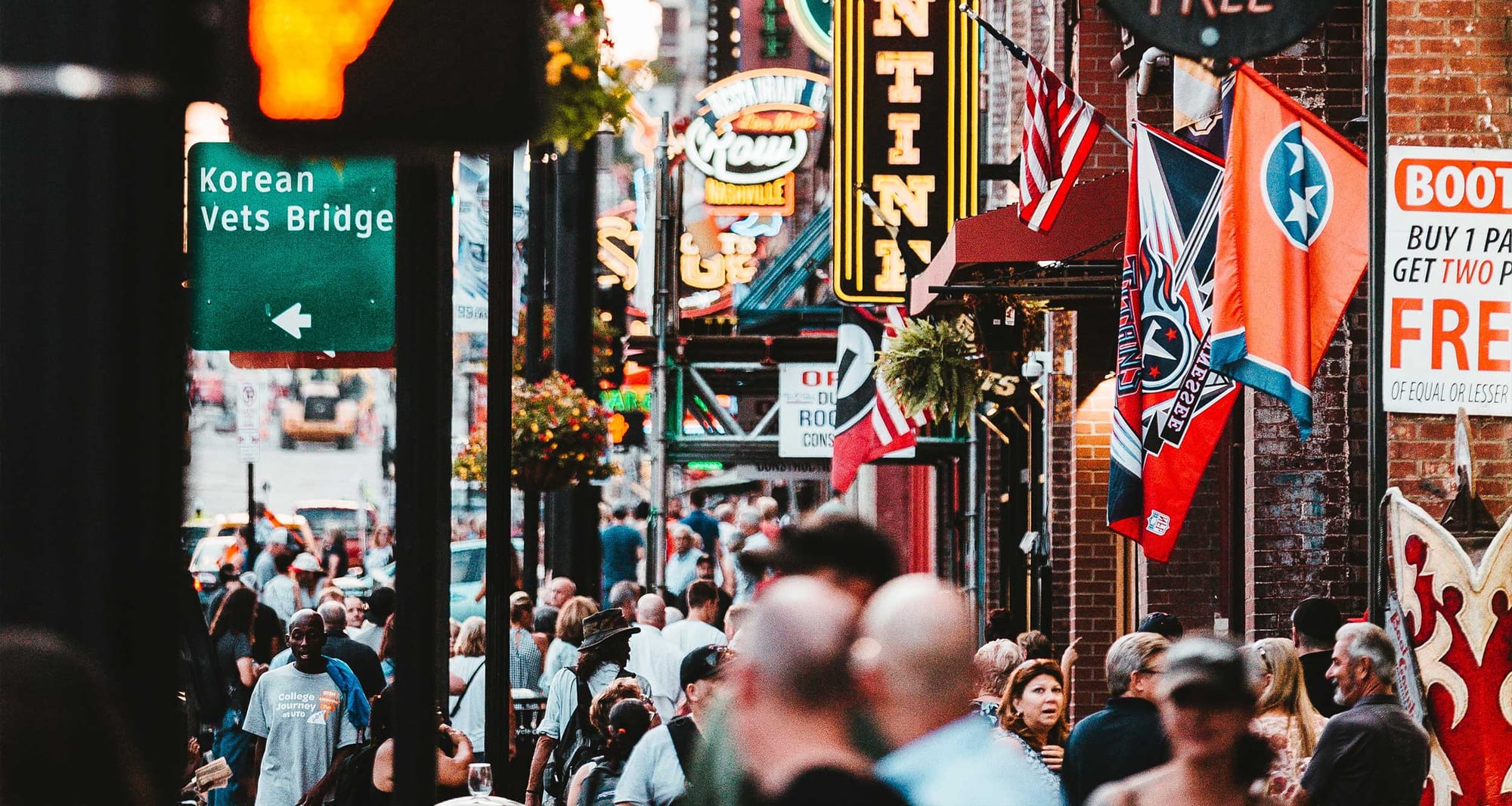 Large group of people walking past the bars on Broadway in Nashville.