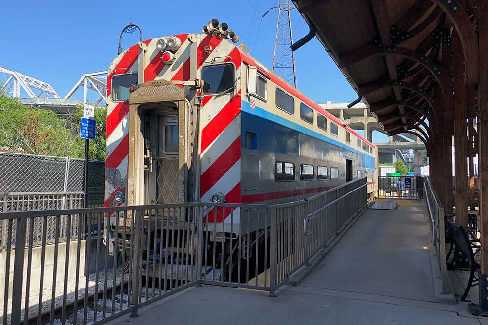 Commuter rail train parked next to wheelchair boarding platform at station.