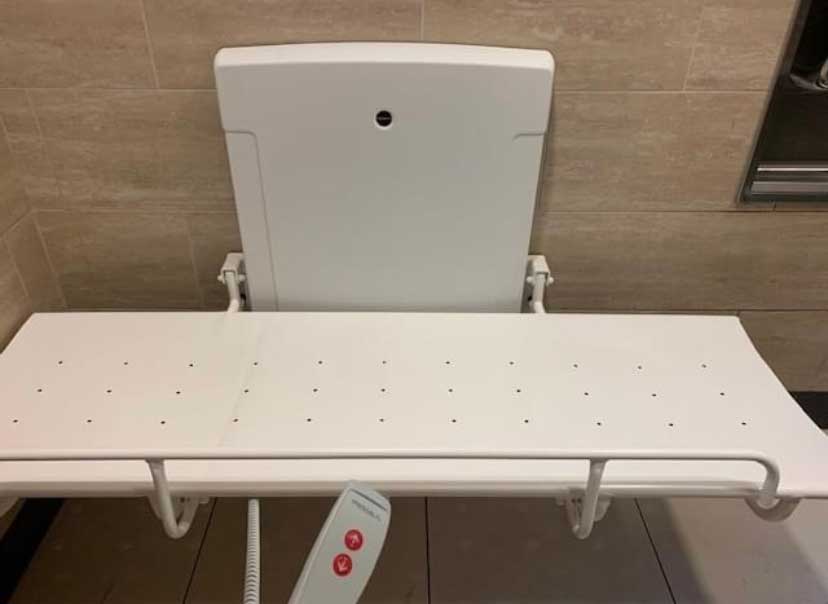 Adult changing table with remote for adjusting table height.