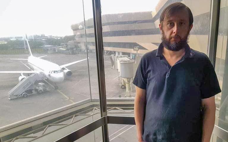 Roman Trofimov posing for photo in front of airport window.