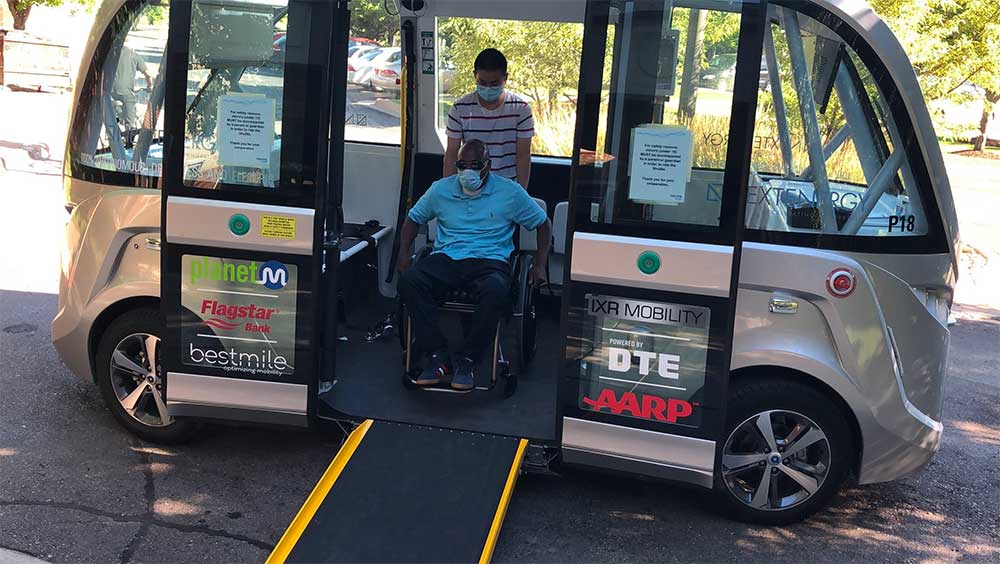 Wheelchair user preparing to exit autonomous vehicle via a ramp.