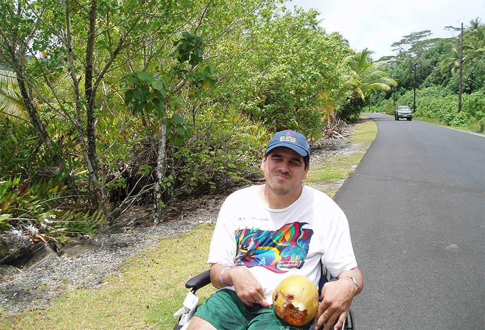 Gordon sitting in his wheelchair on a road.