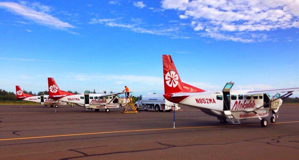 Three Mokulele Airlines airplanes parked at airport.