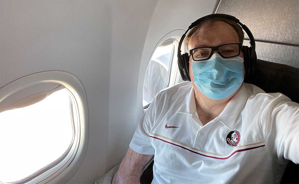 Wearing a face mask while seated on airplane.