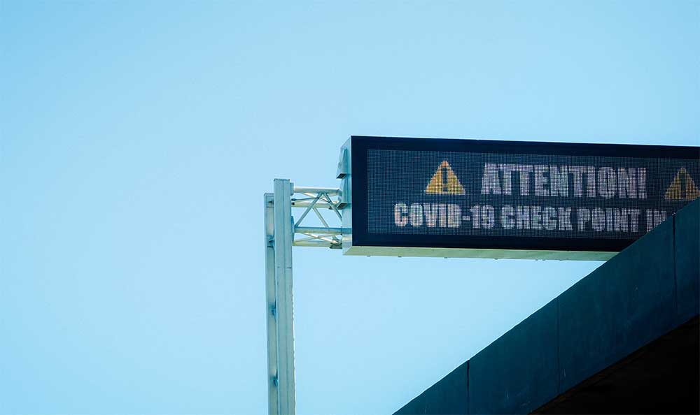 Digital road sign that reads: Attention! Covid-19 checkpoint.