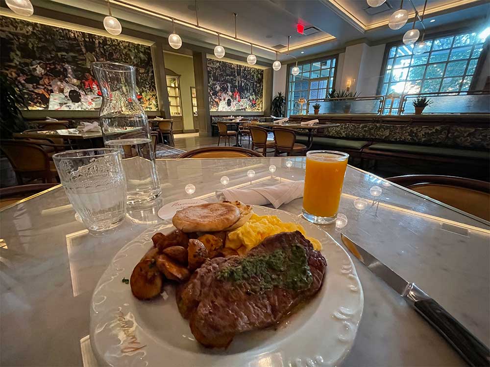 Plate with streak and eggs on restaurant table.