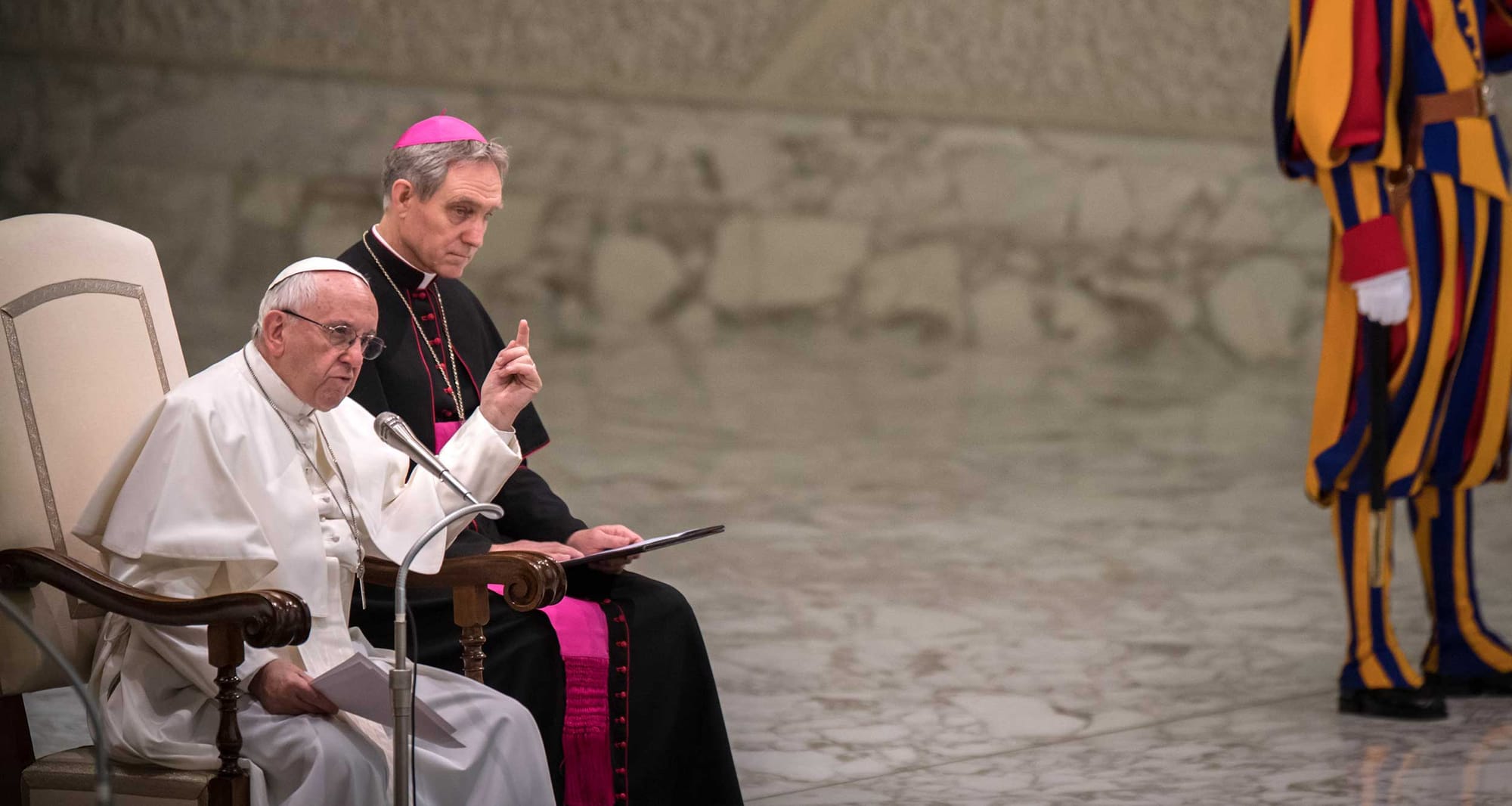 Pope Francis delivering a speech, with arm raised and finger pointed for emphasis.