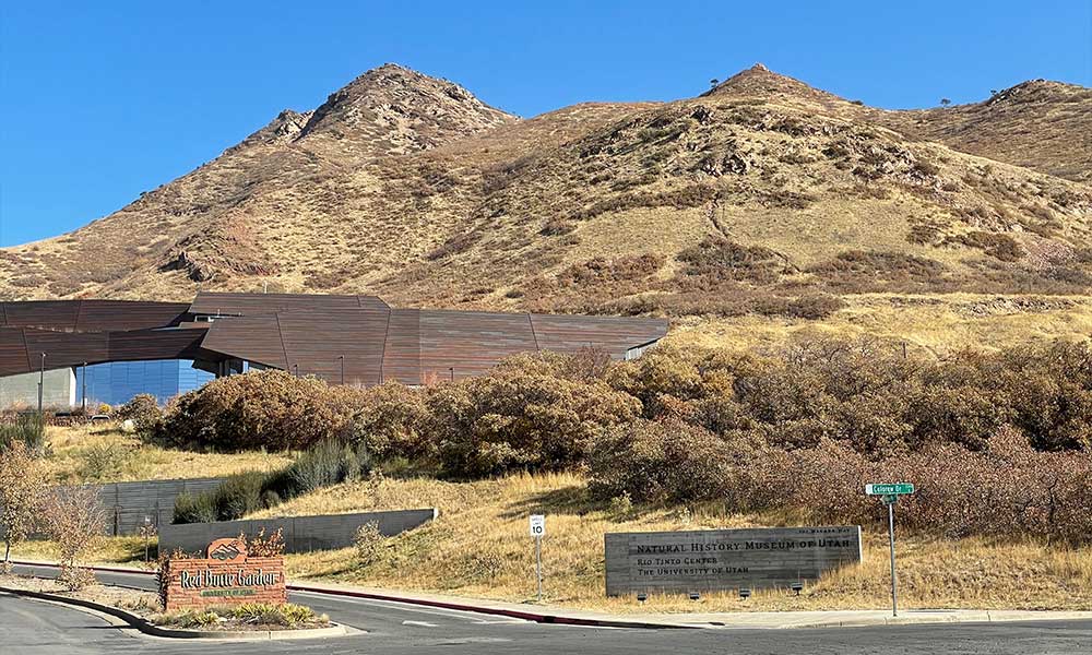 Museum directly in front of grass-covered mountain.