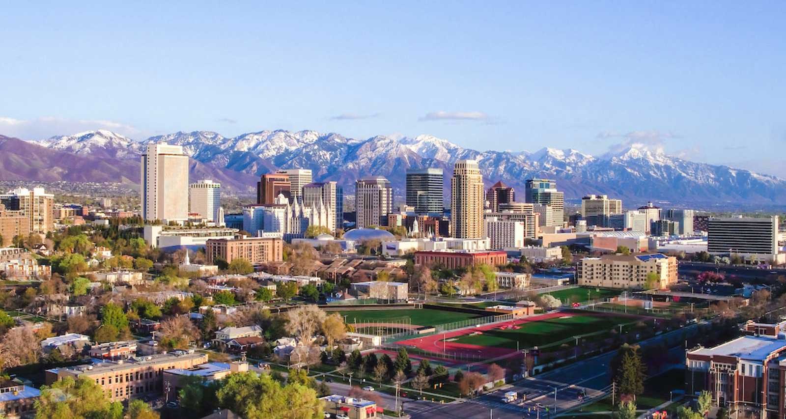 Salt Lake City skyline with snow-capped mountains in the background.