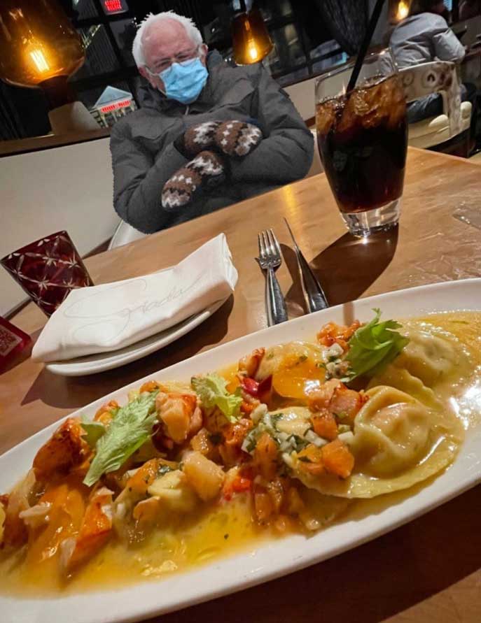 Plate of ravioli, seated opposite table is Bernie Sanders meme.